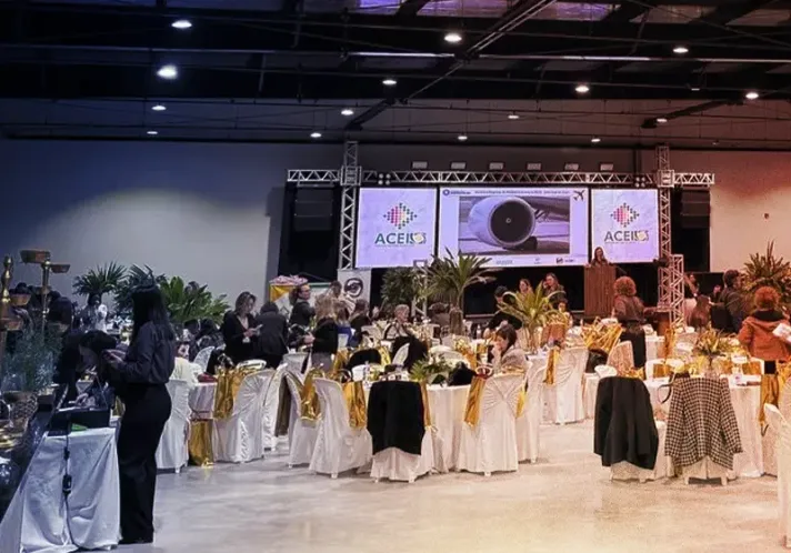 Evento no Centro de Eventos Complexo do Louvor em Ituporanga SC, com mesas decoradas e público reunido.